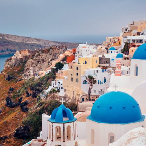 Famous greek iconic selfie spot tourist destination Oia village with traditional white houses and church in Santorini island on sunset in twilight, Greece